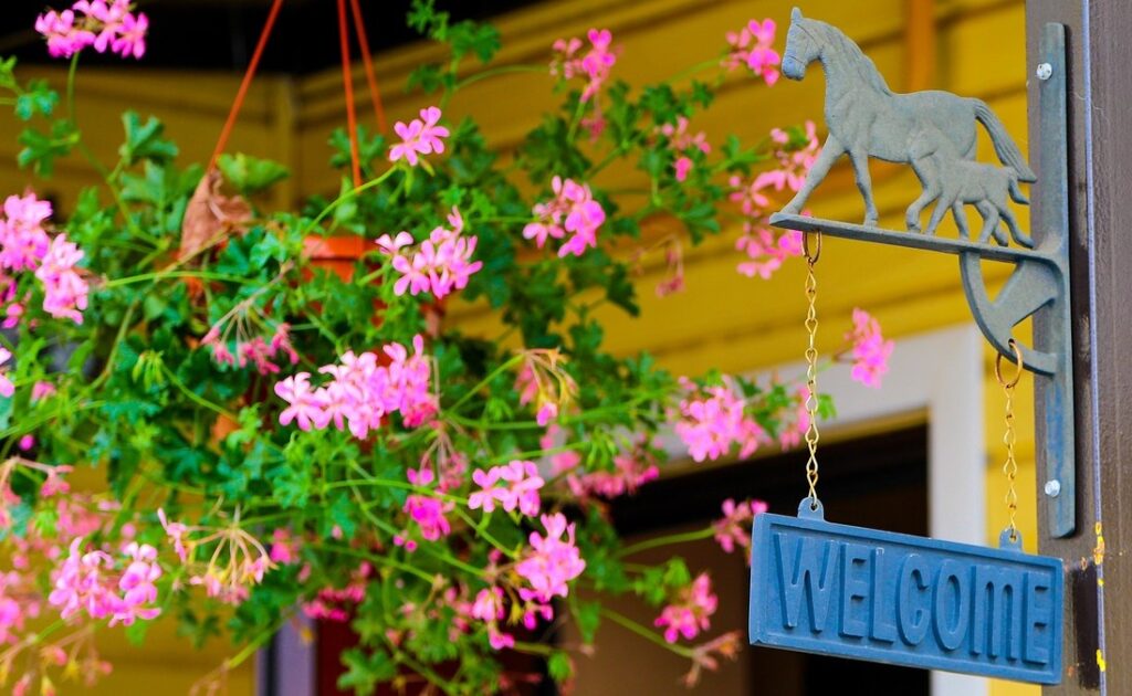 The welcome board and flower plants are there at the entrance of the house