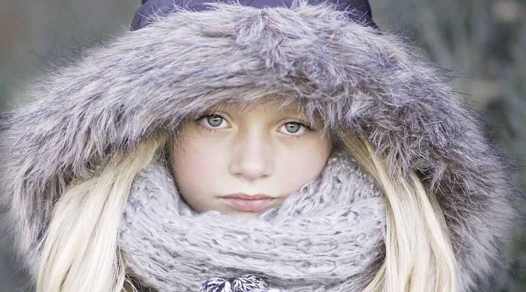 girl shows the face from covered scarf