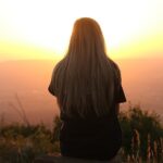 A woman sitting and watching the sunrise