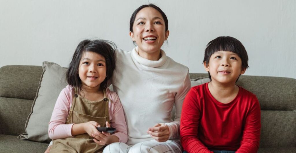 A mother with children happily sit and watching tv