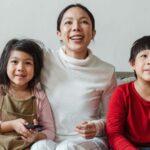 A mother with children happily sit and watching tv