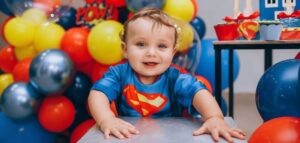 A baby with super hero dress in a party background