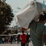 A man carries his luggage on his shoulder