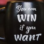 A black colour cup has the message that you can win if you want