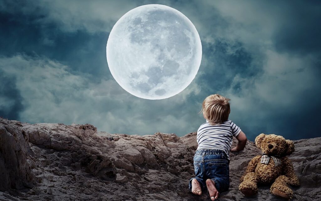 A child having his toy near and seeing the full moon