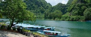 The river passing by the boats waiting on greenery bank